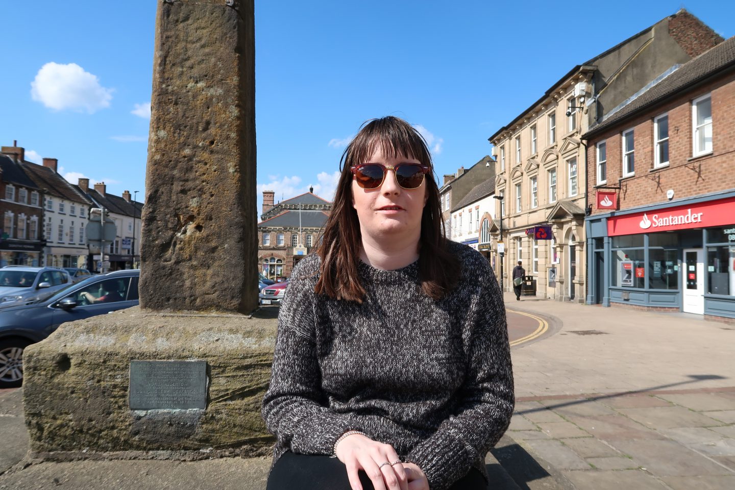 A photo of Holly sat on a market cross