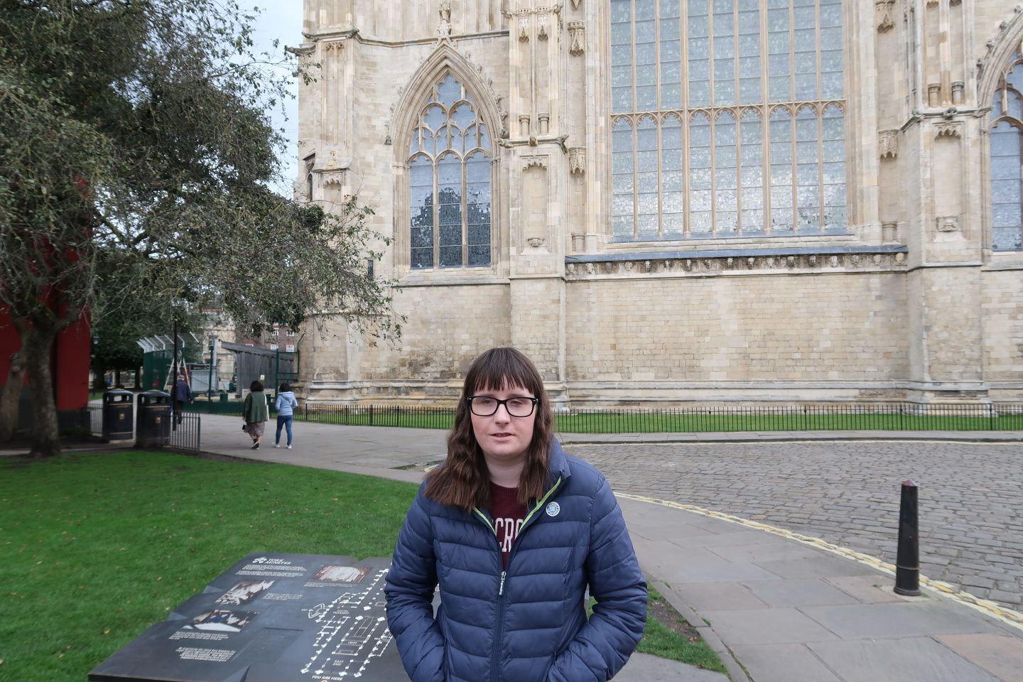 A photo of holly stood in front of York Minster, wearing blue Superdry jacket